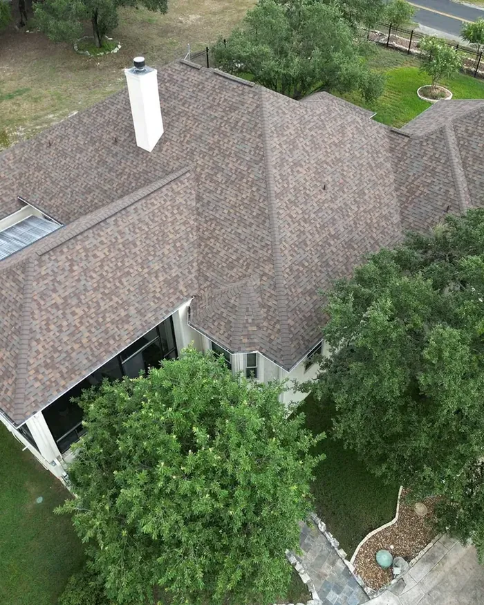 White gutters and downspouts hung along a new roof edge